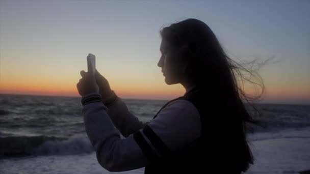 Chica tomando fotos en la playa. Disparo de mano — Vídeos de Stock