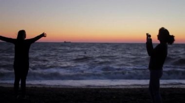 Anne yapar kızı deniz gün batımında fotoğrafı. El atış