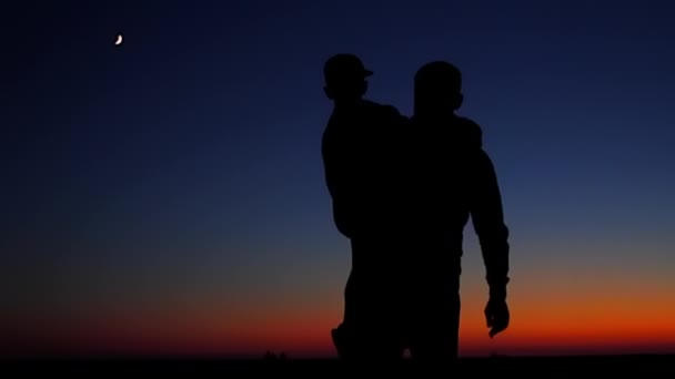 Gelukkige familie: vader en zoon zien uit de zon. Silhouetten — Stockvideo