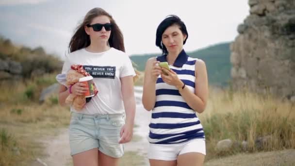 Retrato de duas amigas bonitas com café e smartphone na cidade velha — Vídeo de Stock
