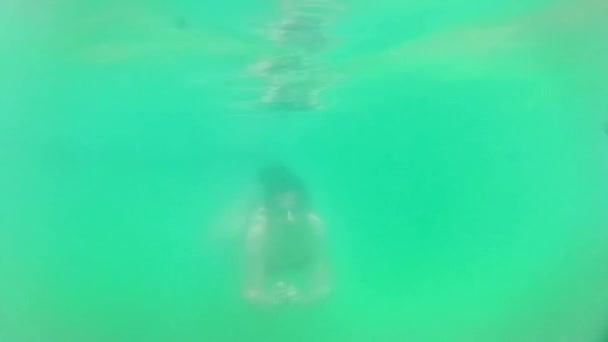 Young teen girl swimming underwater to us — Stock Video