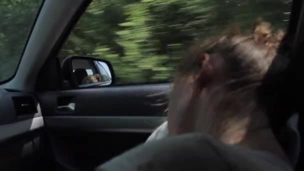 Άνεμος πνέει κορίτσια τα μαλλιά. Κουρασμένος έφηβο κορίτσι κοιμάται στο αυτοκίνητο — Αρχείο Βίντεο