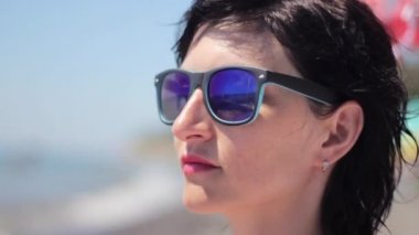 Tropik sahilde güneş gözlüklü güzel genç kadın portresi kapatın