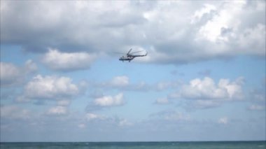 bulutlar deniz üzerinde uçan helikopter