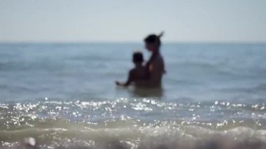 Siluetleri anne ve küçük oğlu denizde Yüzme