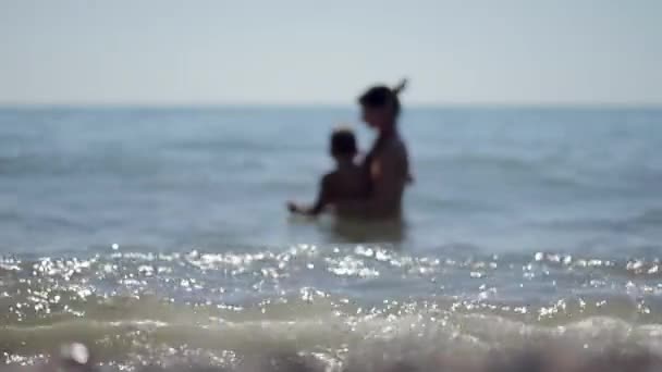 Siluetas madre e hijo pequeño nadando en el mar — Vídeo de stock