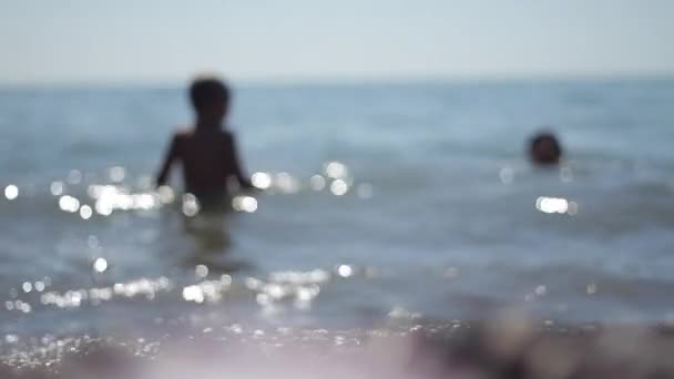 Siluetas madre e hijo pequeño nadando en el mar — Vídeo de stock