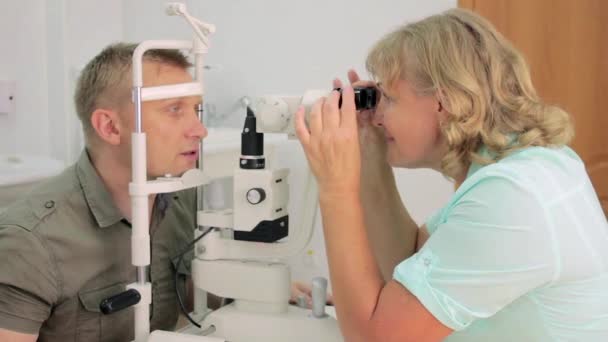 Чоловік має очі оглянуті лікарем — стокове відео
