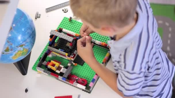 Niño jugando con un conjunto de juguetes de construcción — Vídeos de Stock