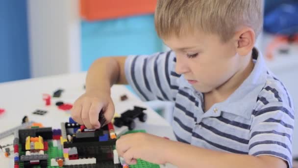 Niño jugando con un conjunto de juguetes de construcción — Vídeo de stock