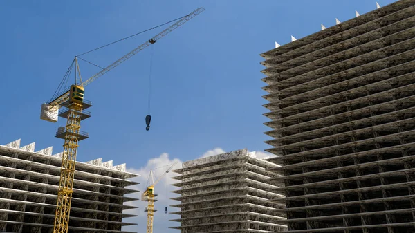 Hög byggnad under uppbyggnad. Sida med kranar mot blå himmel med solsken. 3d-konvertering — Stockfoto