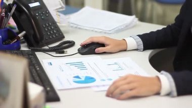 Klavye ve finansal belgeler üzerinde çalışan kadının elleri
