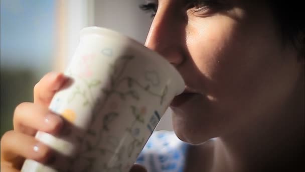 Mooie vrouw nippen hete stomende drank — Stockvideo