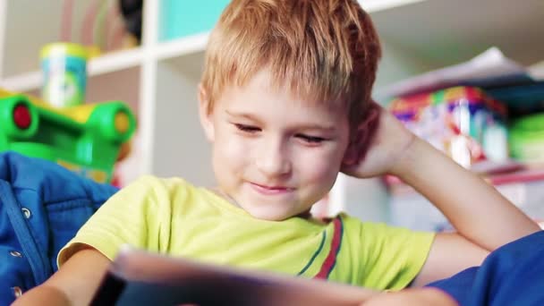 Маленький хлопчик грає на планшеті — стокове відео
