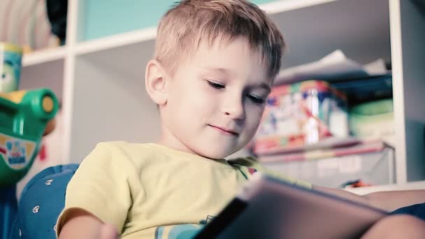 Liten pojke spelar på tabletten — Stockvideo