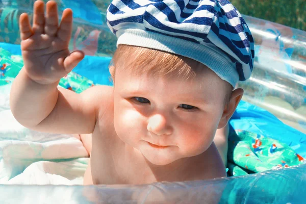 Curious, happy, ten months old baby posing on blue pool — Zdjęcie stockowe