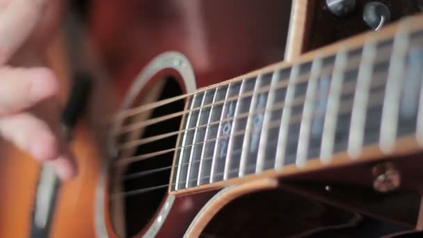 Человек с Тату играет на акустической гитаре — стоковое видео