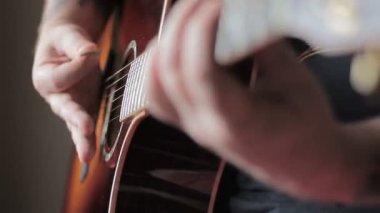 Akustik gitar çalmak dövme olan adam