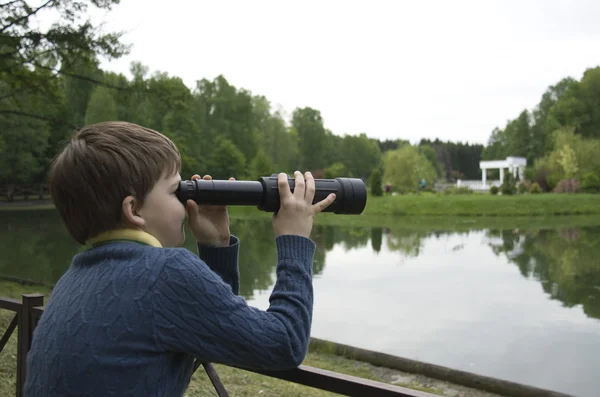 Pojke 10 år i parken tittar på fåglarna genom spyglass — Stockfoto