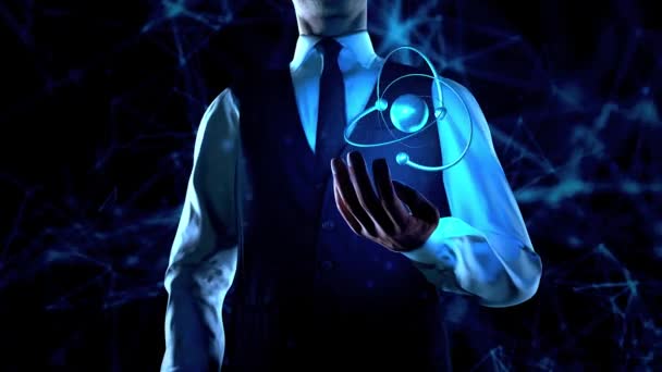 Бизнесмен держит атомную частицу в левой руке с сетевыми линиями подключения — стоковое видео