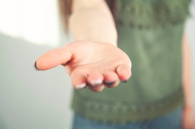 Gri bir arka planda kadının eli açık