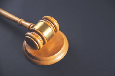 Tahta mahkeme tokmağı siyah arka planda. Adaletin, hakimin ve duruşmanın sembolü. 
