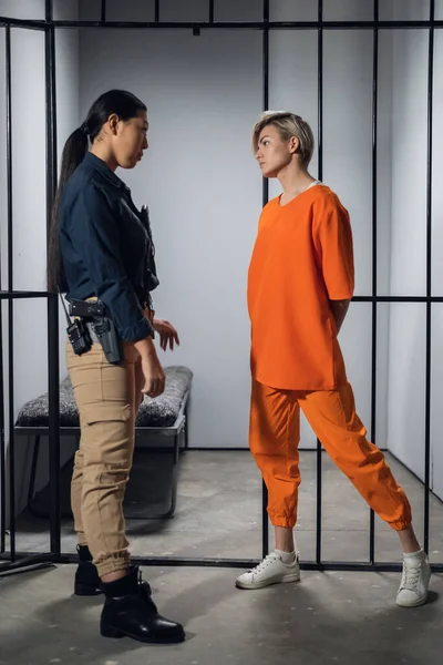 Блондинка в азіатській в'язниці загальної безпеки виведена з її камери уніформою охоронця, з зашифрованим пістолетом і walkie-talkie . — стокове фото