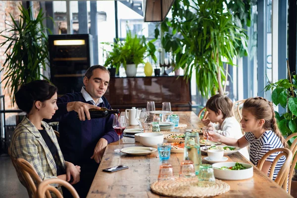 Une famille de quatre personnes dînant dans un café — Photo