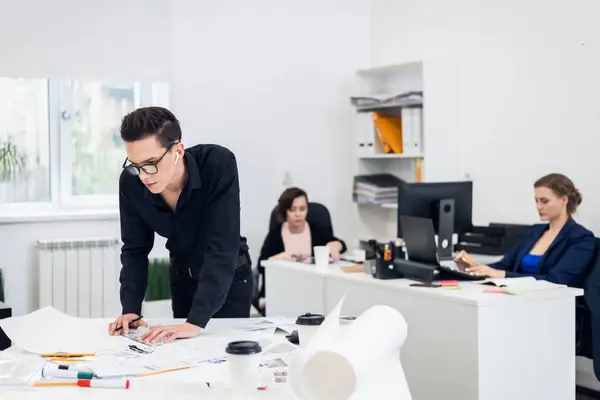 Un apuesto arquitecto joven de aspecto inteligente en gafas de trabajo o — Foto de Stock