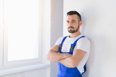 Mavi önlüklü adam kollarını göğsüne kadar katladı.