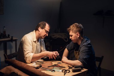 Şirin bir genç adam kendi elleriyle hediye yapmak ister. Deneyimli bir ayakkabıcı deriden ayakkabı yapmasına yardım eder..