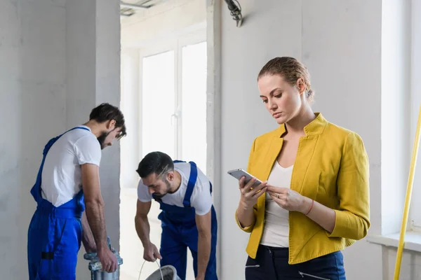 Affärskvinna pratar i telefon i en renoverad lägenhet — Stockfoto