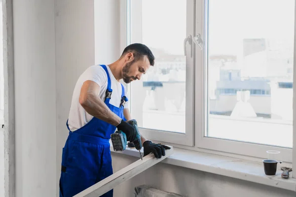 Constructor in overalls folded his arms over his chest — Stock Photo, Image