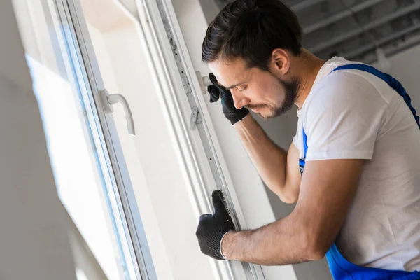 Der Bauherr baut einen Fensterrahmen in den Raum ein — Stockfoto