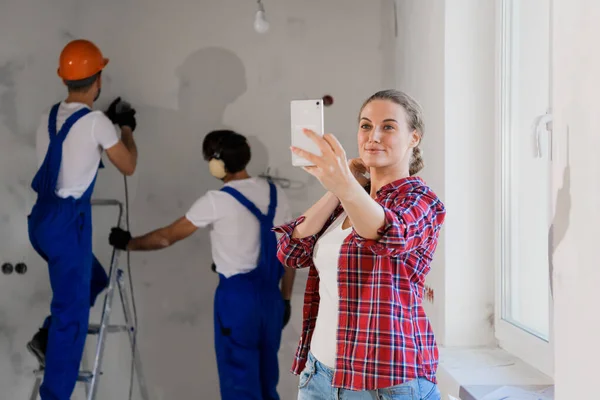 Glückliche Frau macht Selfie mit Arbeiterin in Arbeitskleidung — Stockfoto