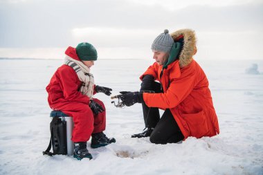 Tecrübeli bir balıkçı baba, küçük oğluna kışın balık avlamak için teçhizat kullanmayı öğretir..