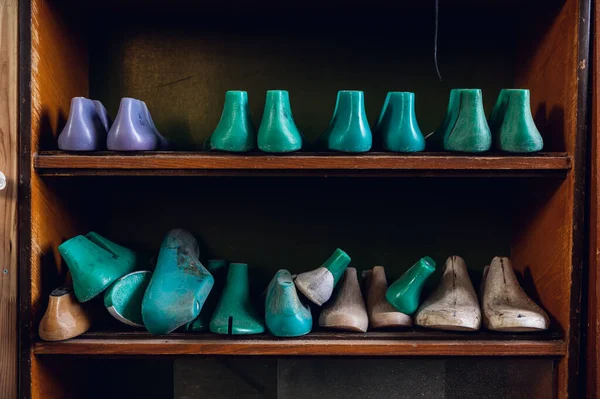 En el taller en un estante de madera se colorean espacios en blanco para diferentes zapatos —  Fotos de Stock