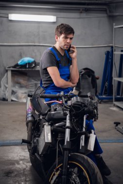 Bisiklette oturan ve telefonda konuşan bir tamirci.