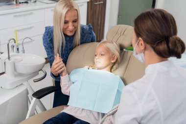 A parent and a scared child at the dentists office, the mother