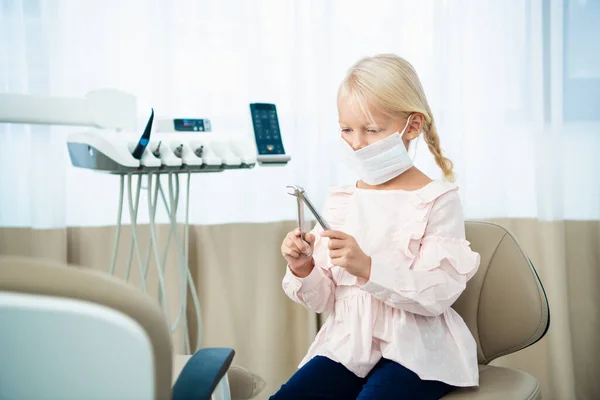 Medical, stomatology and health care concept. A kid playing with dental tools during her pediatric dentistry visit at dental clinic — Φωτογραφία Αρχείου