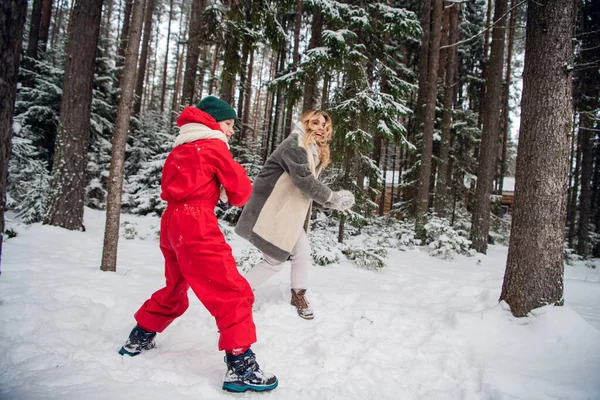 Na floresta de inverno em um passeio, mãe e filho jogar neve, diversão jogos de família — Fotografia de Stock
