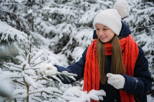 Uma jovem encantadora desfruta das férias de ano novo e da primeira neve na floresta. — Fotografia de Stock