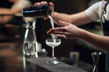 Deneyimli bir barmen alkollü kokteyl hazırlar. Yüz yok, yakın plan, kopyalama alanı.
