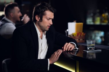 Genç bir adam barda çok içti, barda sarhoş bir şekilde kokteyl içti.