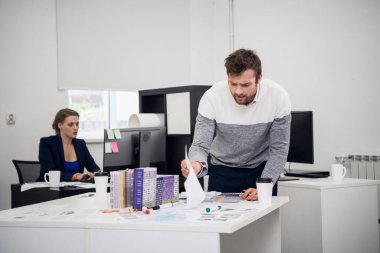 Genç bir ofis çalışanı dağınıklığıyla ilgili bazı belgeler arıyor.