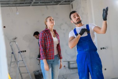 Müteahhit müşteriye dairenin nasıl yenilendiğini gösteriyor.