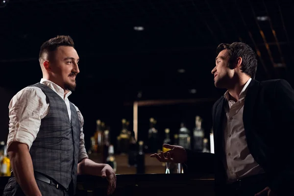 Conversa divertida homens em camisa e colete e homens em camisa e jaqueta no bar — Fotografia de Stock