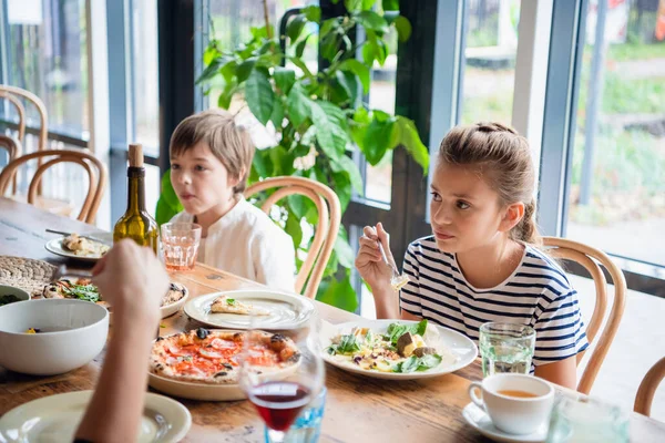 The kids sitting at the dinner table, a boy and a girl. — Stockfoto