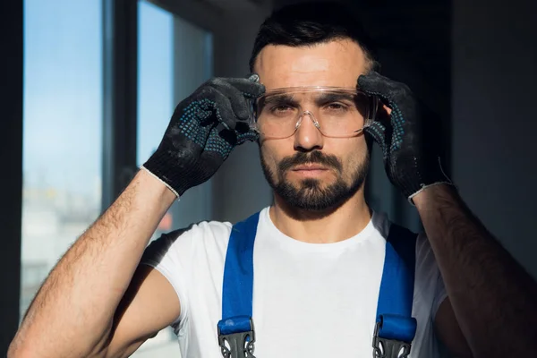 Close up, bearded construction worker wearing protective glasses — Stockfoto