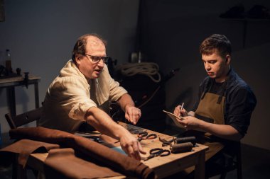 Baba-ayakkabıcı atölyesinde el yapımı ayakkabı deneyimini oğluna aktarır..